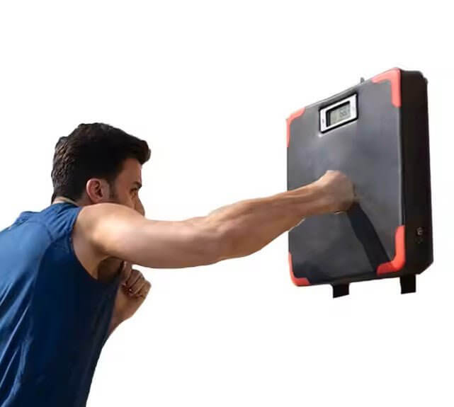 Person using Kondimaster HIT Wandboxkissen, measuring punch strength with smart sensor on display.
